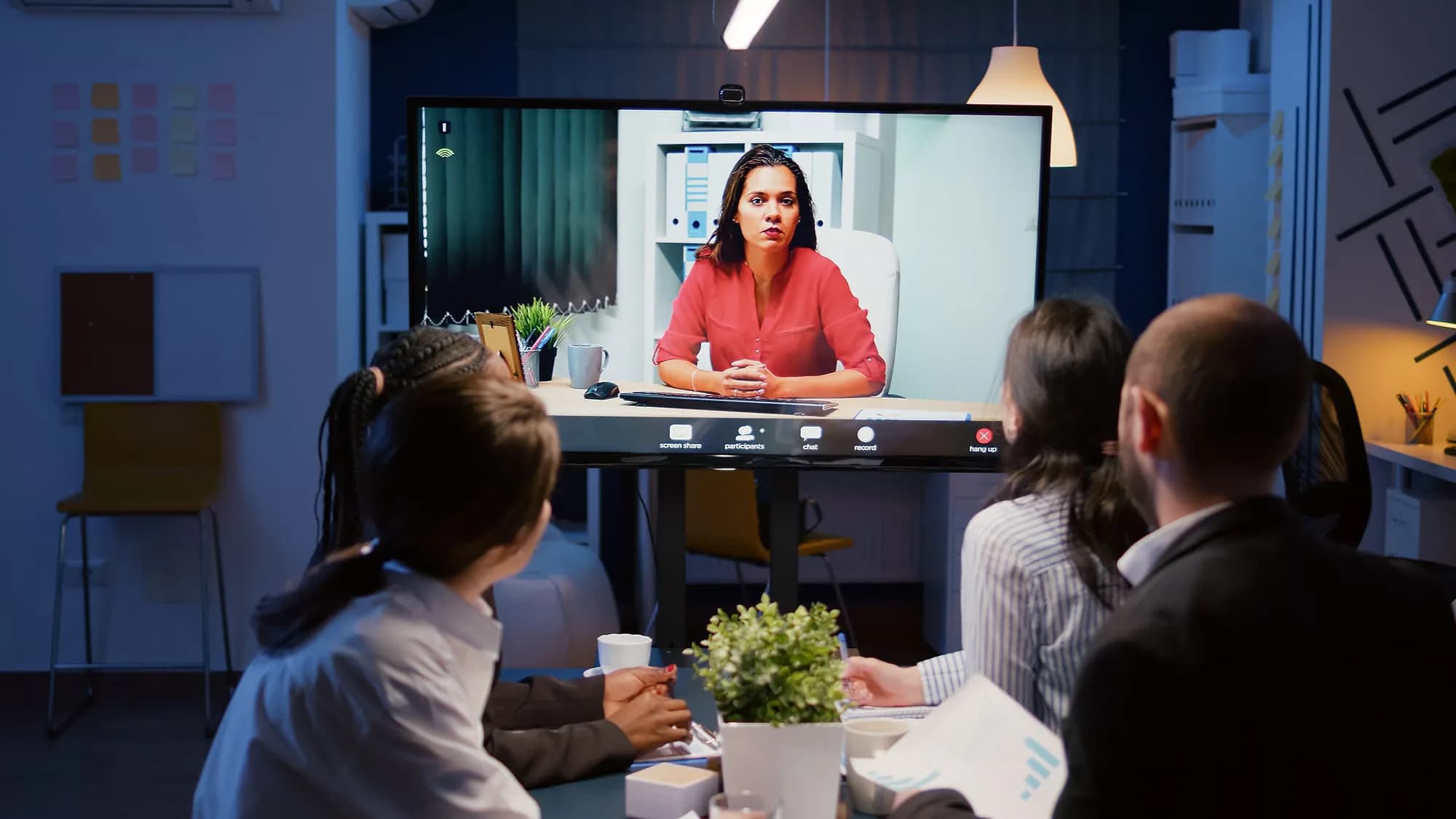 Team in a video-conference classroom session with a remote instructor on screen